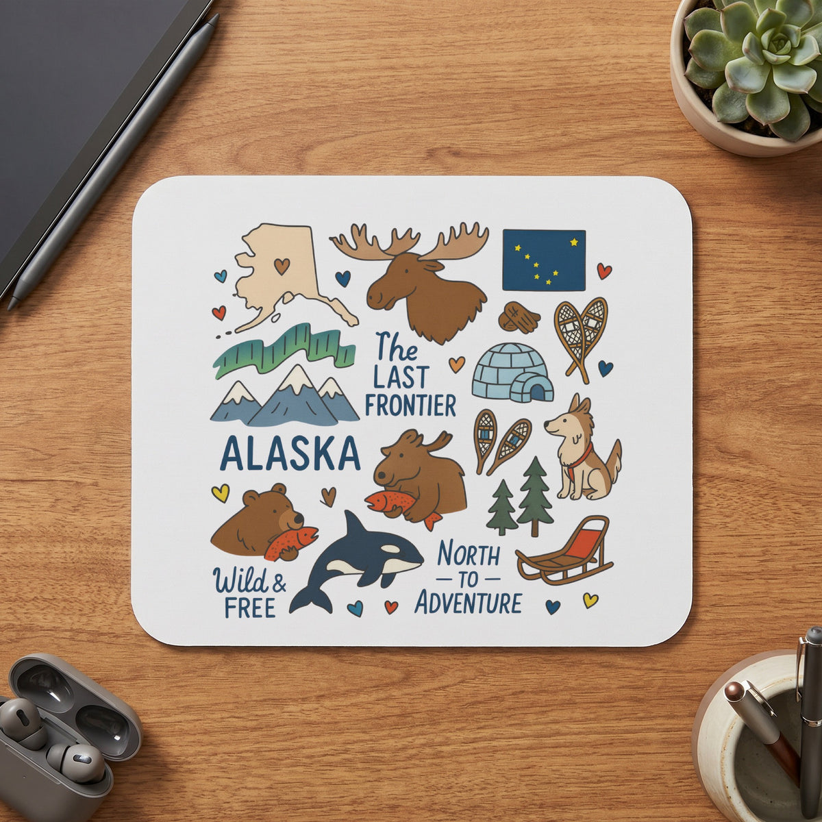 Alaska themed mousepad with illustrations of wildlife, mountains, and the text "The Last Frontier".