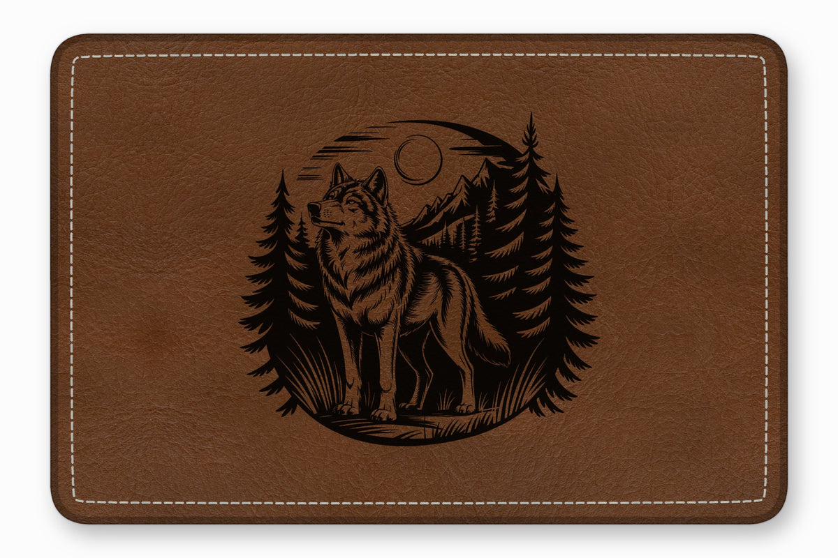 Brown leather rectangular mat with white stitching and a black engraved wolf and forest design.