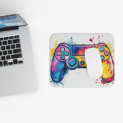 Watercolor game controller design on a mousepad next to a laptop.
