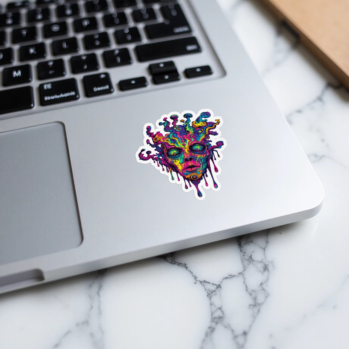 Colorful abstract face sticker with melting effect on laptop keyboard
