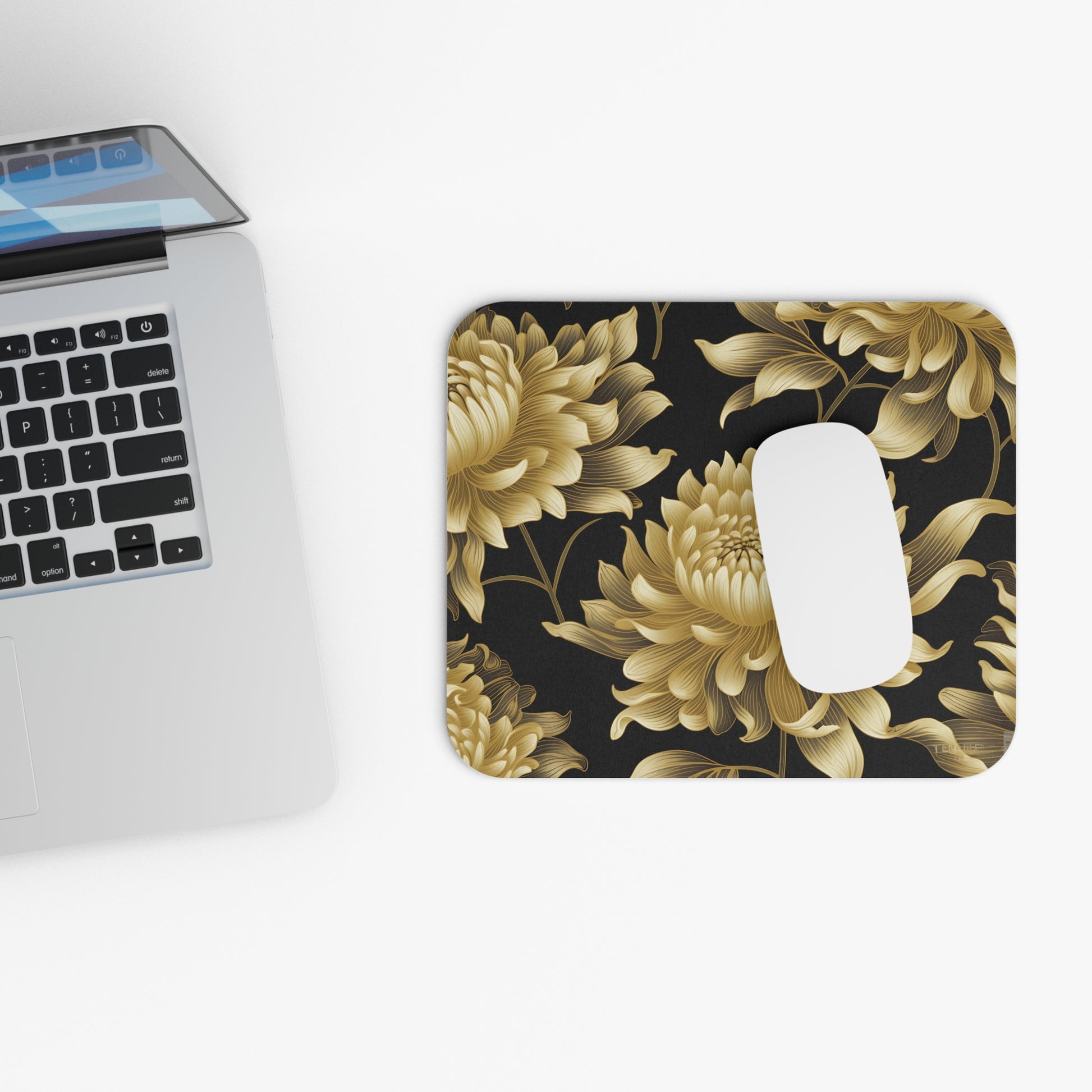 Mousepad with a gold floral pattern on a black background and a white mouse.