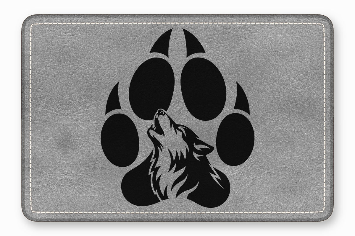 A grey textured leather patch features a black graphic of a howling wolf within a paw print.