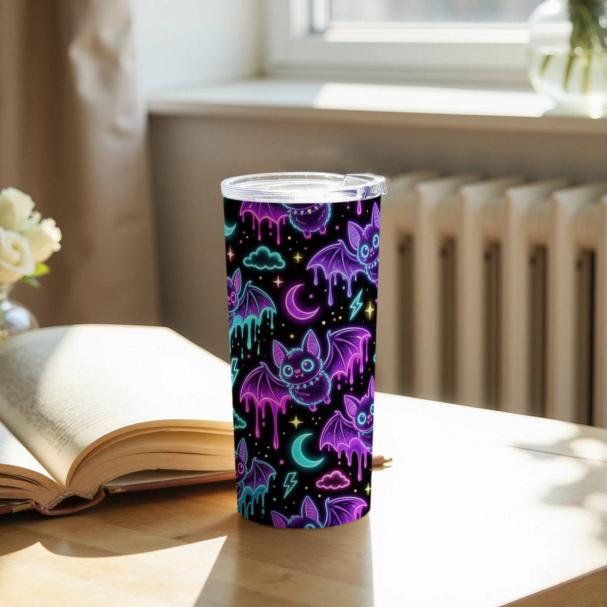 Tumbler with a black background featuring a neon glowing pattern of bats, moons, and clouds.