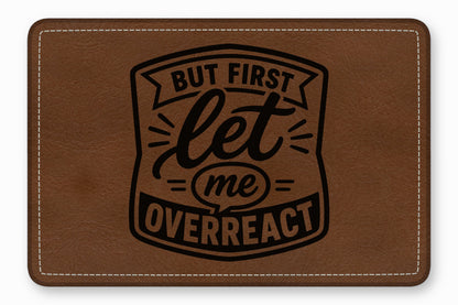 Brown faux leather patch with white stitched border and black engraved text reading But first let me overreact.