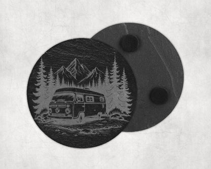 Round slate coaster etched with a vintage camper van, pine trees, and mountains.