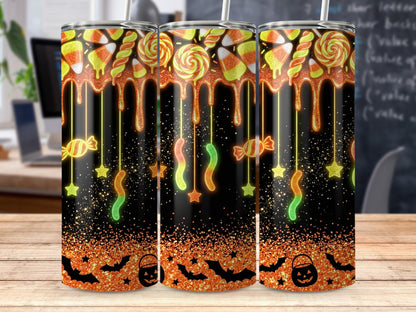 Tumbler with Halloween candy, dripping orange glaze, bats, and pumpkin bucket.