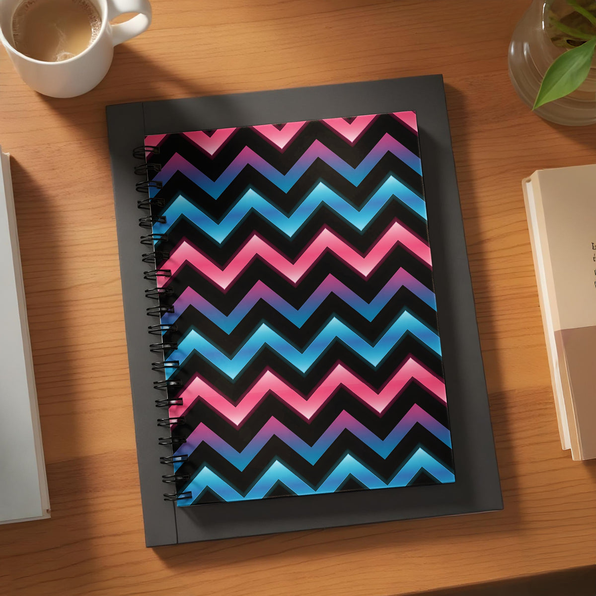 Spiral notebook with black background and pink and blue chevron pattern.