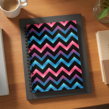 Spiral notebook with black background and pink and blue chevron pattern.