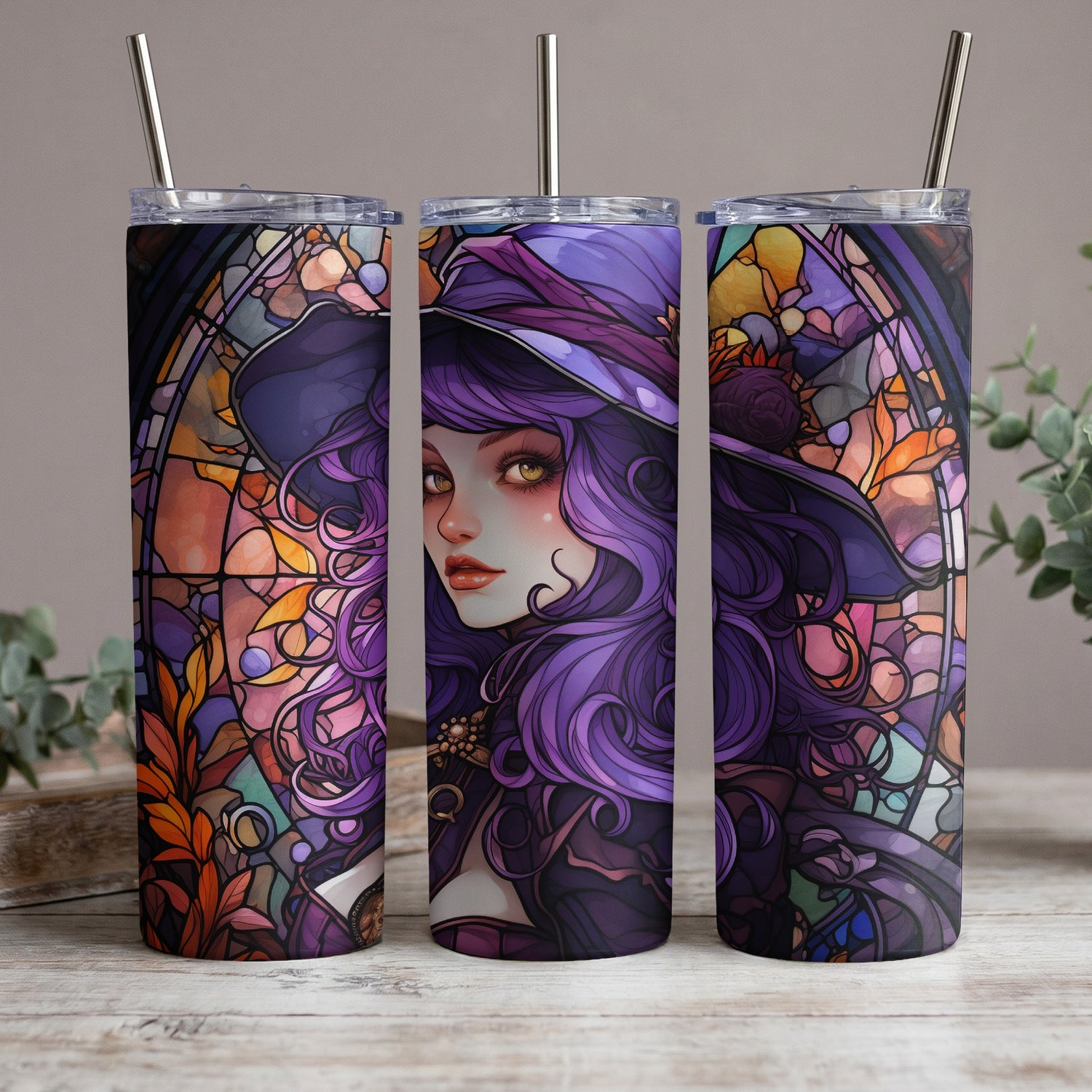 Three tumblers with stained-glass witch art and metal straws.