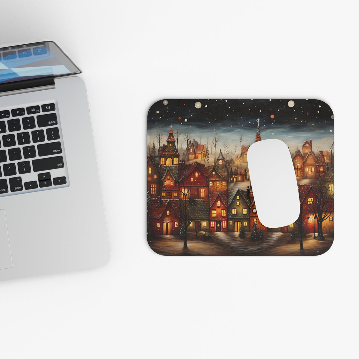 Mousepad with a whimsical winter village scene and a white computer mouse.