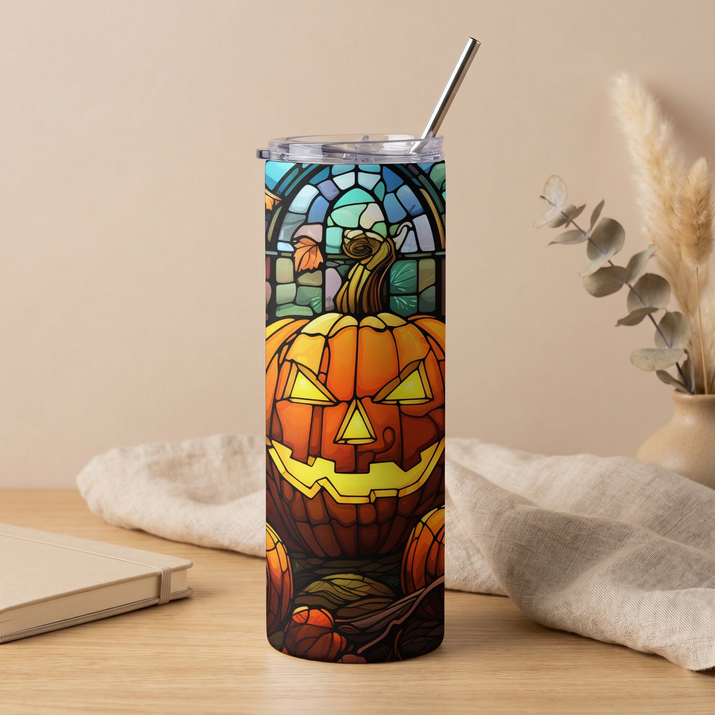 Stainless steel tumbler with stained glass pumpkin design and metal straw.