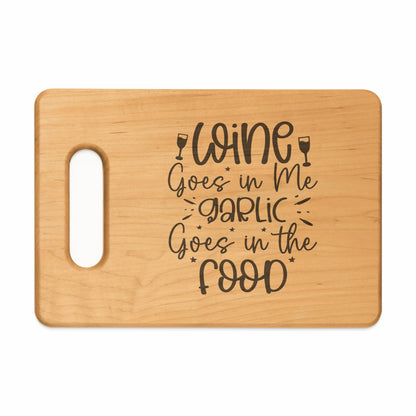 Wooden cutting board with carved text "Wine Goes in Me, Garlic Goes in the Food".