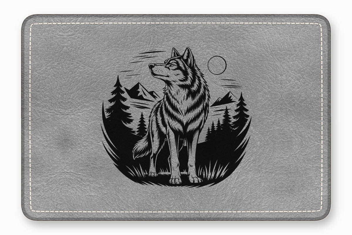 Gray faux leather mouse pad featuring a black engraved graphic of a wolf in a forest.