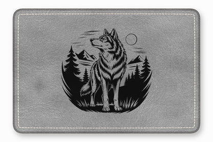 Gray faux leather mouse pad featuring a black engraved graphic of a wolf in a forest.
