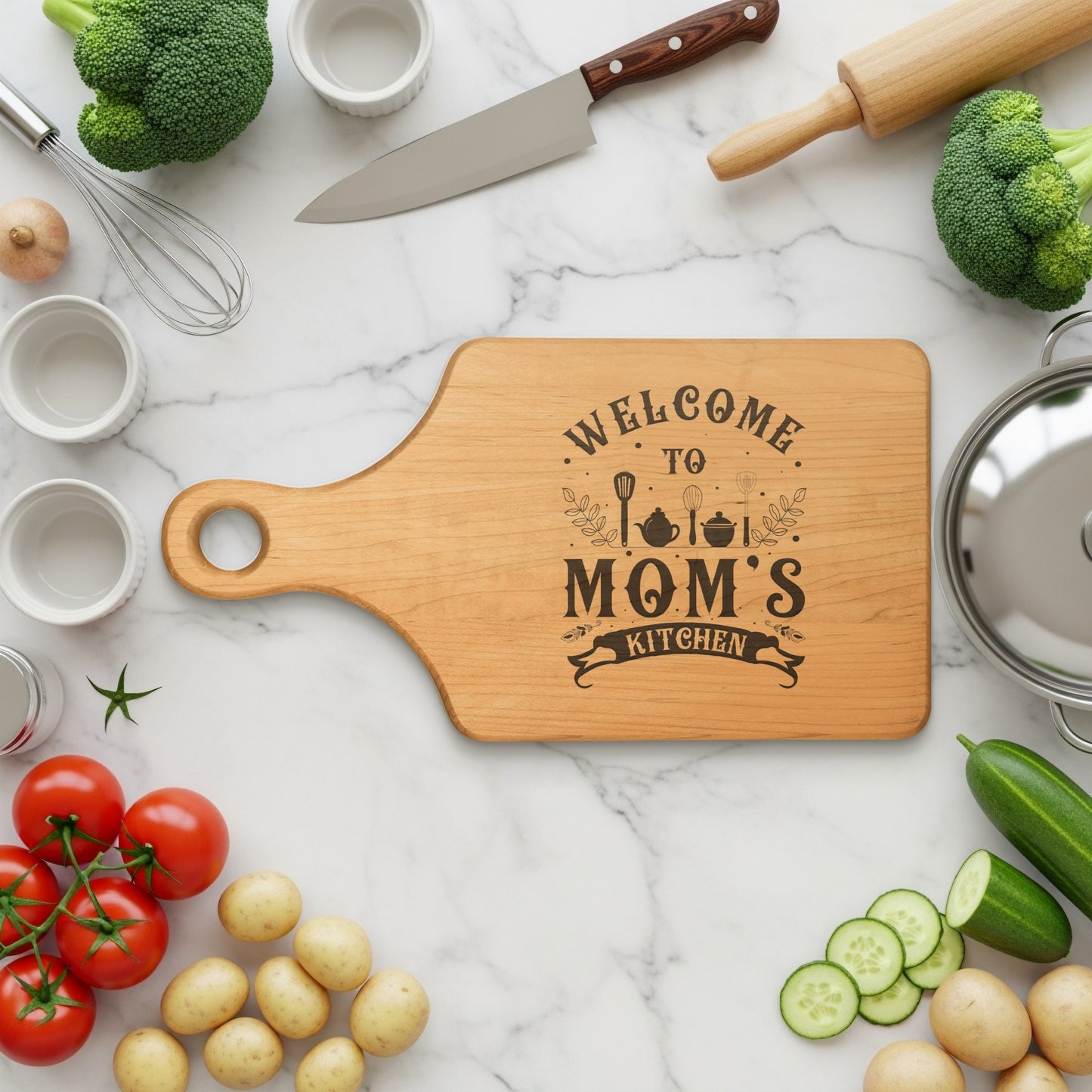 Wooden cutting board with "Welcome to Mom's Kitchen" engraved text.