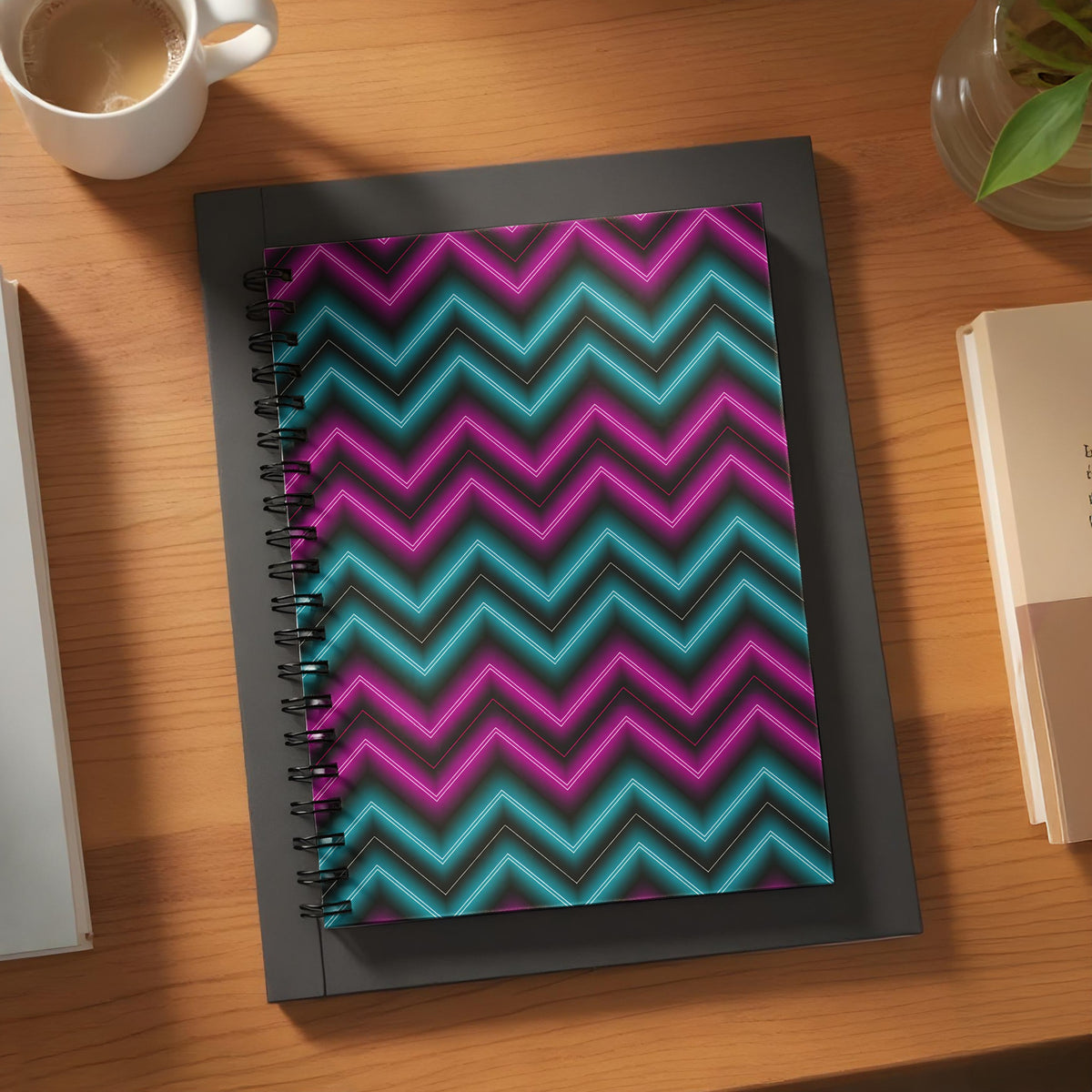 Spiral notebook with neon pink and blue chevron pattern on black background.