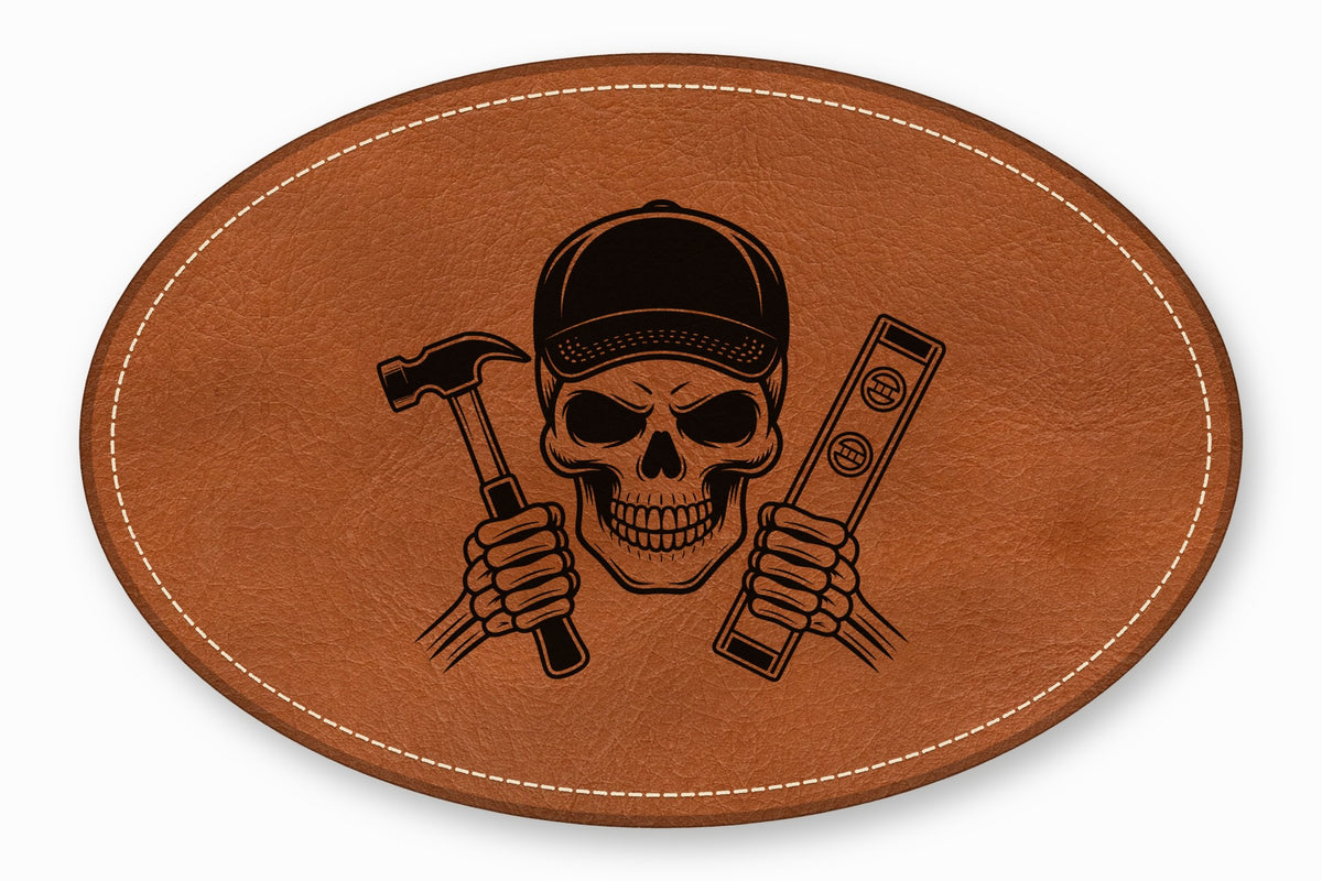 An oval brown leather patch with white stitching featuring a black skull wearing a cap and holding a hammer and level.