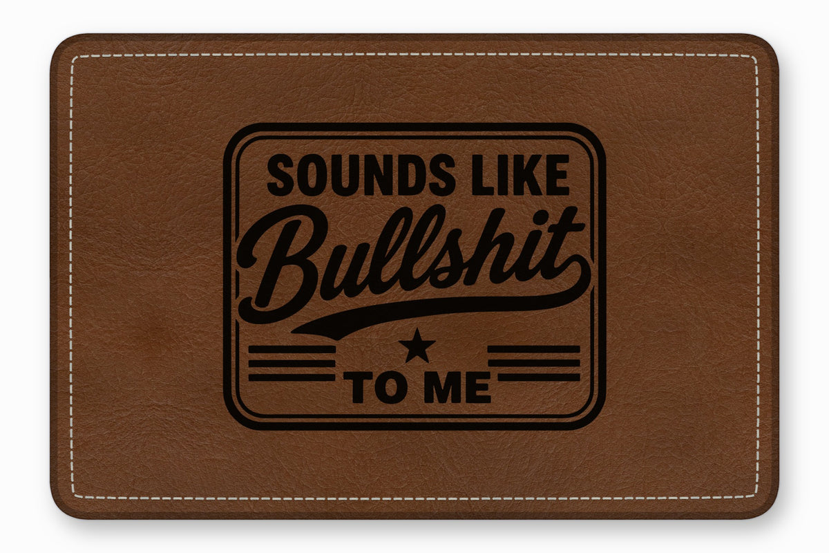 Brown leather patch with white stitching and the engraved text Sounds Like Bullshit To Me.