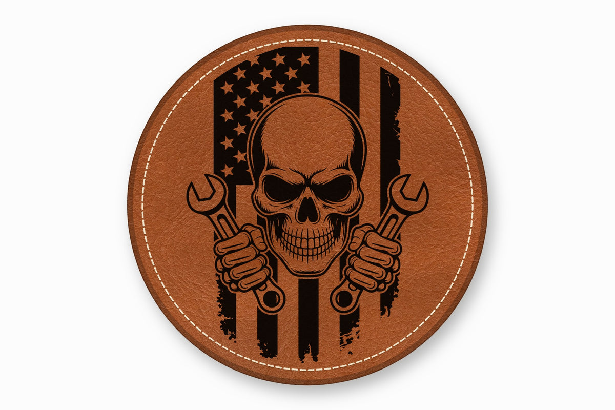 Round brown leather patch laser-engraved with an American flag, a skull, and two wrenches.