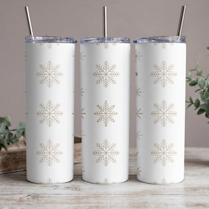 Three white tumblers with gold snowflake pattern, each with a metal straw.