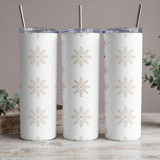 Three white tumblers with gold snowflake pattern, each with a metal straw.
