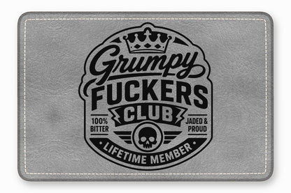 A rectangular grey leather patch featuring a black vintage-style emblem with text that reads Grumpy Fuckers Club.