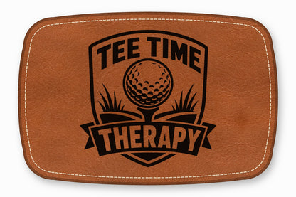 Brown leather patch with rounded corners, white stitching, and a black golf-themed design reading Tee Time Therapy.