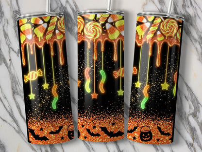 Halloween tumbler with candy corn, lollipops, gummy worms, bats, and jack-o'-lantern.
