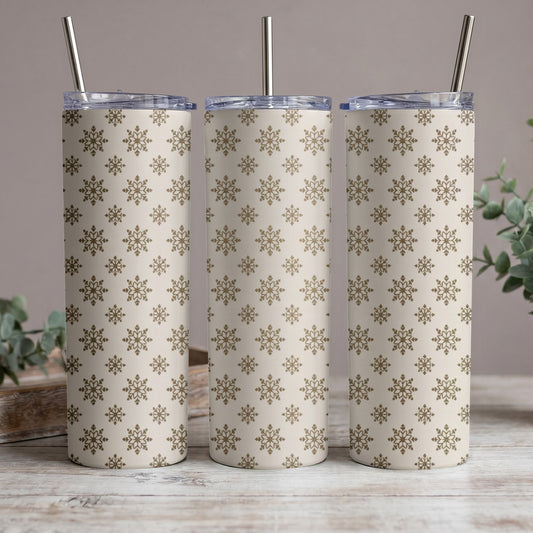 Three tumblers with a beige and gold snowflake pattern and metal straws.