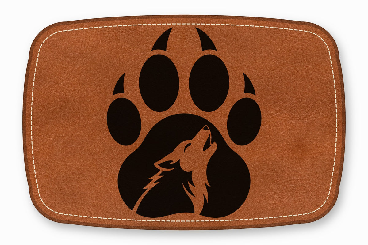 Brown leather rectangular patch with white stitched border and a black paw print containing a howling wolf silhouette.