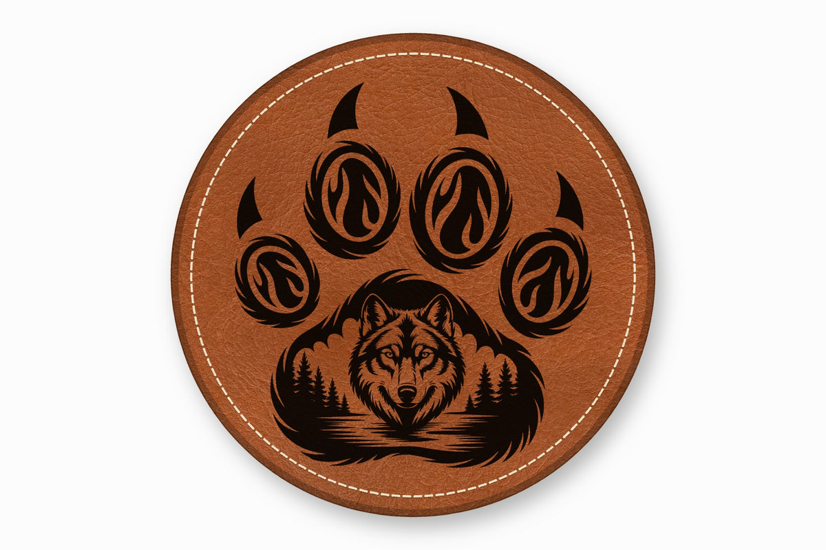 Round brown leather coaster featuring a black laser-engraved wolf face inside a paw print design.