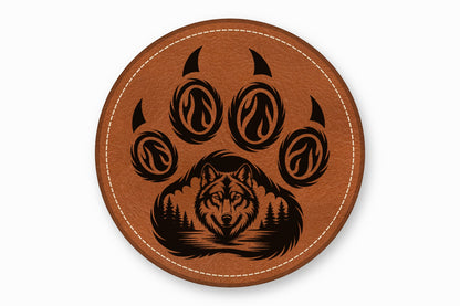Round brown leather coaster featuring a black laser-engraved wolf face inside a paw print design.