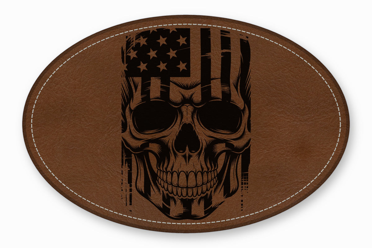 Oval brown leather patch with white stitched border featuring a black engraved American flag skull design.