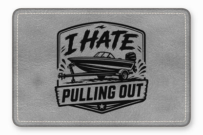 Gray textured faux leather rectangle with rounded, stitched corners and a black boat design bearing the text I HATE PULLING OUT.