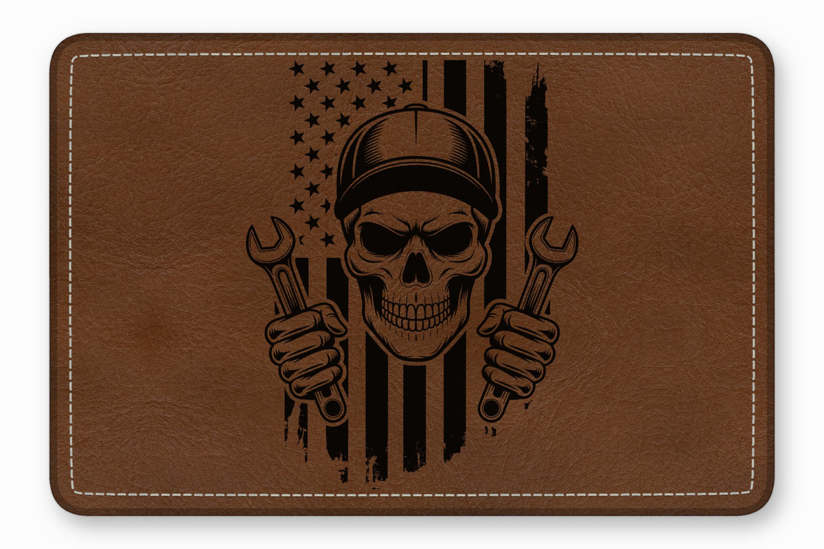 Brown faux leather patch featuring an engraved mechanic skull wearing a cap and holding wrenches against an American flag.
