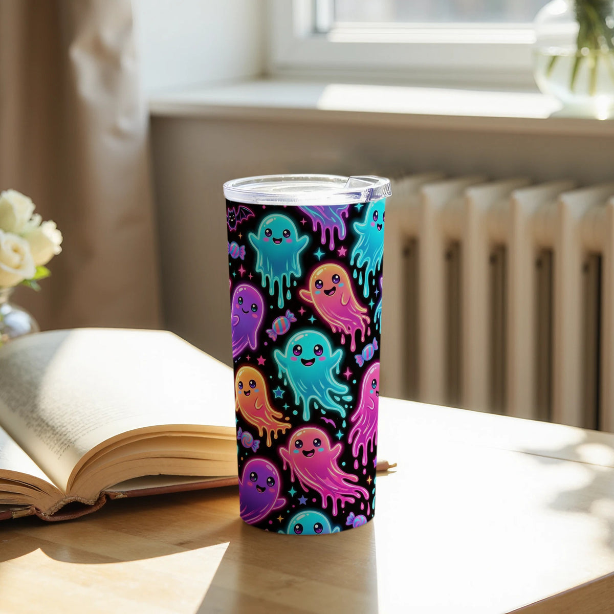 Tumbler with cute colorful ghosts, stars, and candy on a black background.