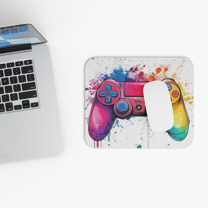 Gaming controller with watercolor paint splatter design on a mousepad next to a laptop.