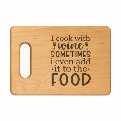 Light wood cutting board with "I cook with wine sometimes i even add it to the FOOD" text.