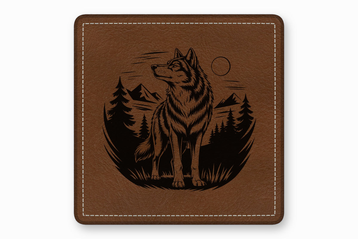 Square brown leather coaster with white stitched border and engraved design of a wolf in a forest.