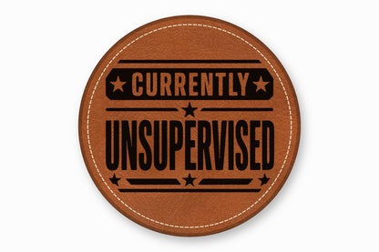 A round brown leather patch with white stitched edges and black text reading Currently Unsupervised.