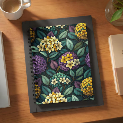 Spiral-bound notebook with a dark floral pattern featuring yellow and purple flowers.