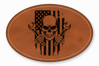 Brown leather oval patch featuring a black laser-engraved skull and cross wrenches over an American flag.