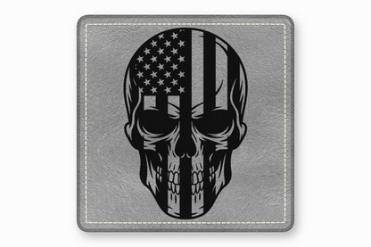 Square grey leather patch with rounded corners featuring a black and white American flag skull graphic and white stitching.