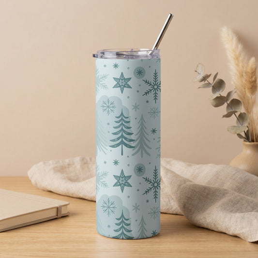 Tall tumbler with a light blue background and a pattern of snowflakes and trees.