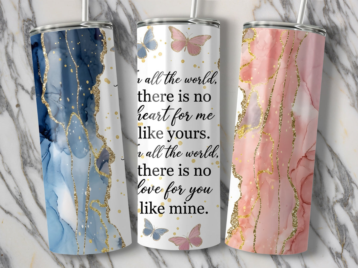 Three tumblers with abstract marbled designs and gold glitter accents.