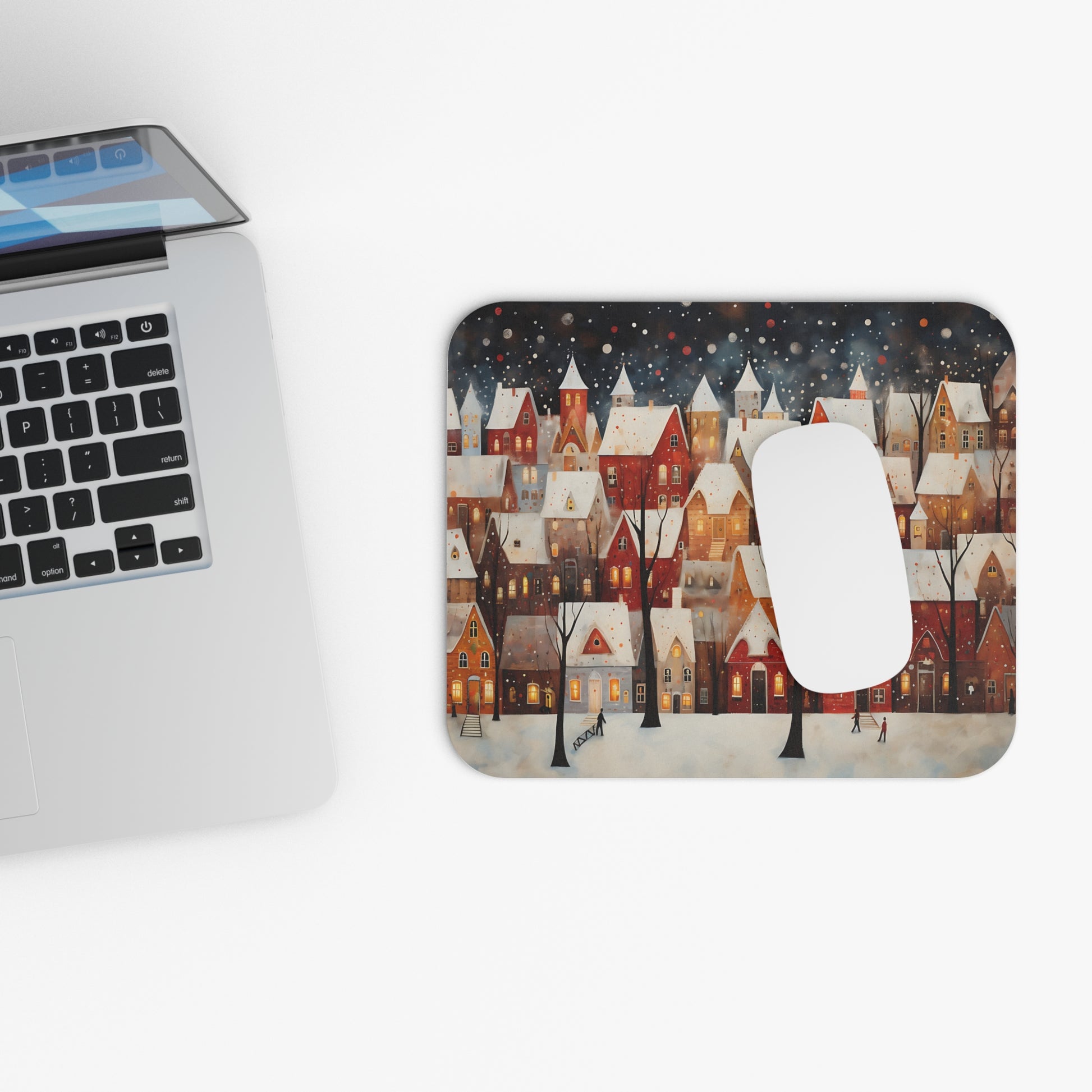 Mousepad with a charming winter village scene featuring snow-covered houses and falling snow.