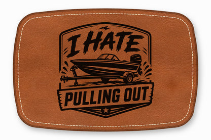 Brown leather patch with white stitching featuring a black graphic of a boat on a trailer and the text I HATE PULLING OUT.
