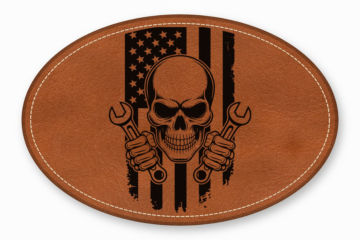 An oval brown leather patch featuring a skull holding wrenches over a distressed American flag design.