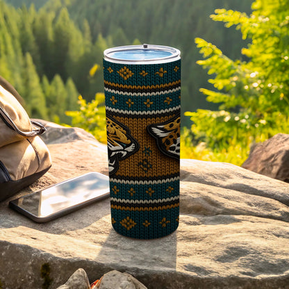Tumbler with jaguar face design on knitted pattern next to a phone and bag.
