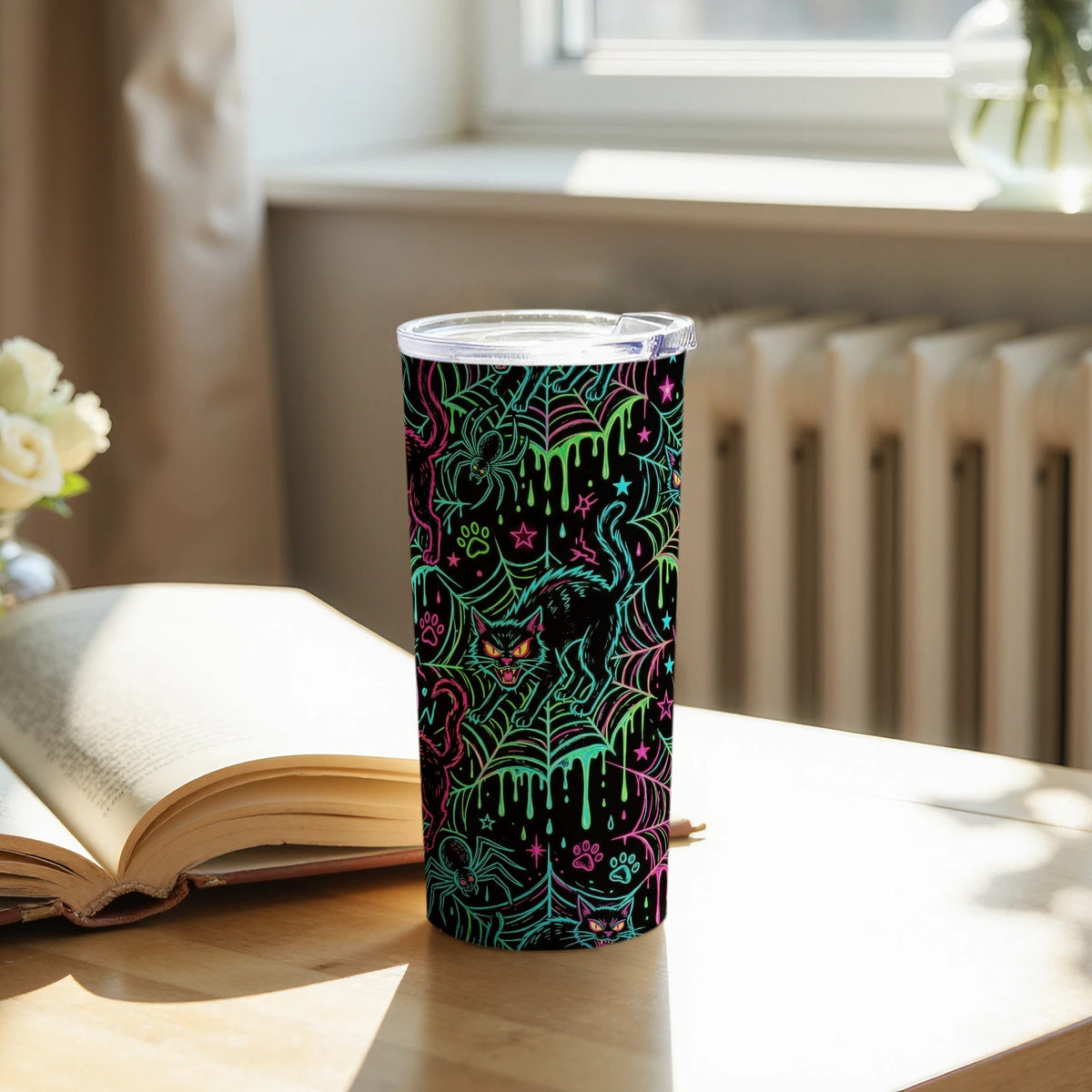 Black tumbler with neon Halloween design of cats, spiders, and spiderwebs.